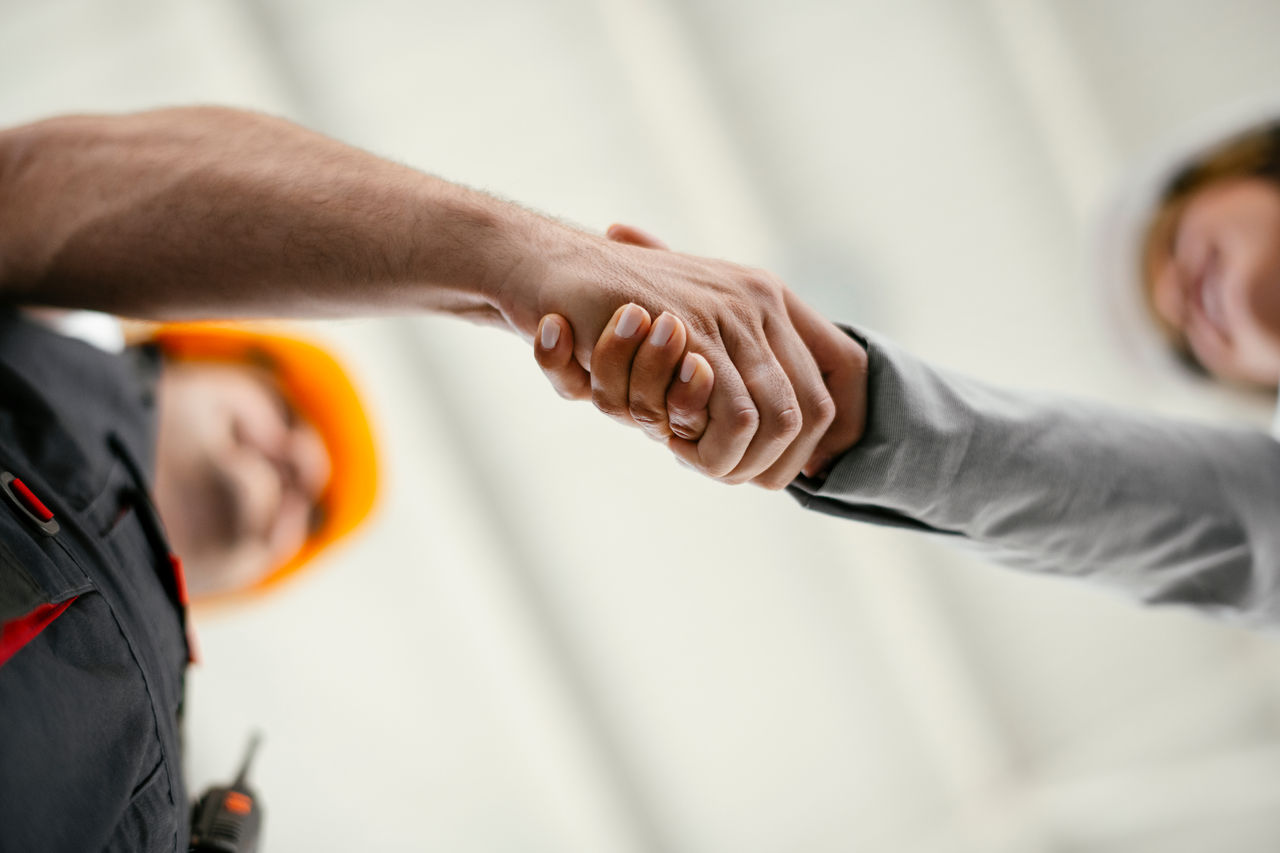 Close up of factory worker giving handshake to a engineer. Business handshake.; Shutterstock ID 1607487217; purchase_order: CON; job: ; client: ; other: 