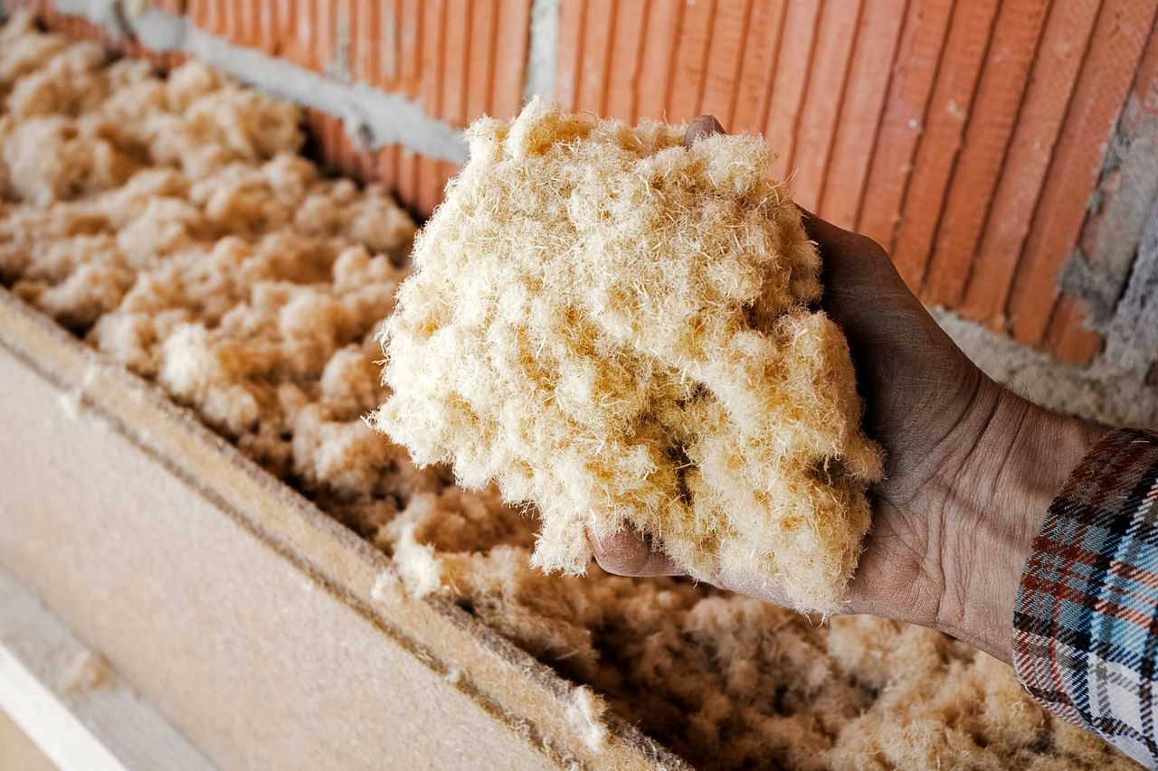 Insulating an Outside Wall, Hand Shows Wood Fiber Insulation Mat; Shutterstock ID 1573259251; purchase_order: CON; job: ; client: ; other: 