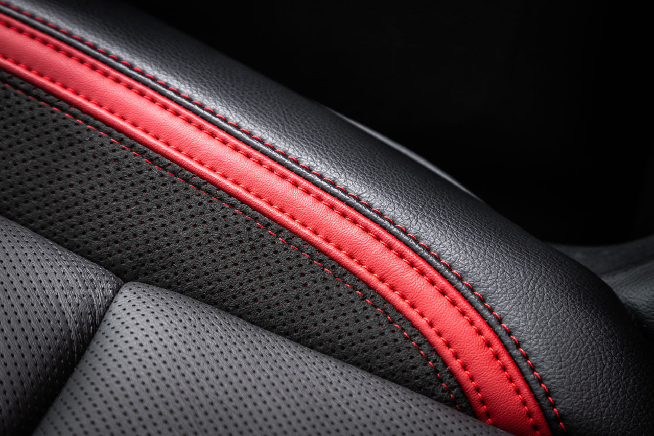 close-up black and red  perforated leather car seat. Skin texture; Shutterstock ID 2300504413; purchase_order: POL Website Automotive_Plastisols; job: ; client: ; other: 