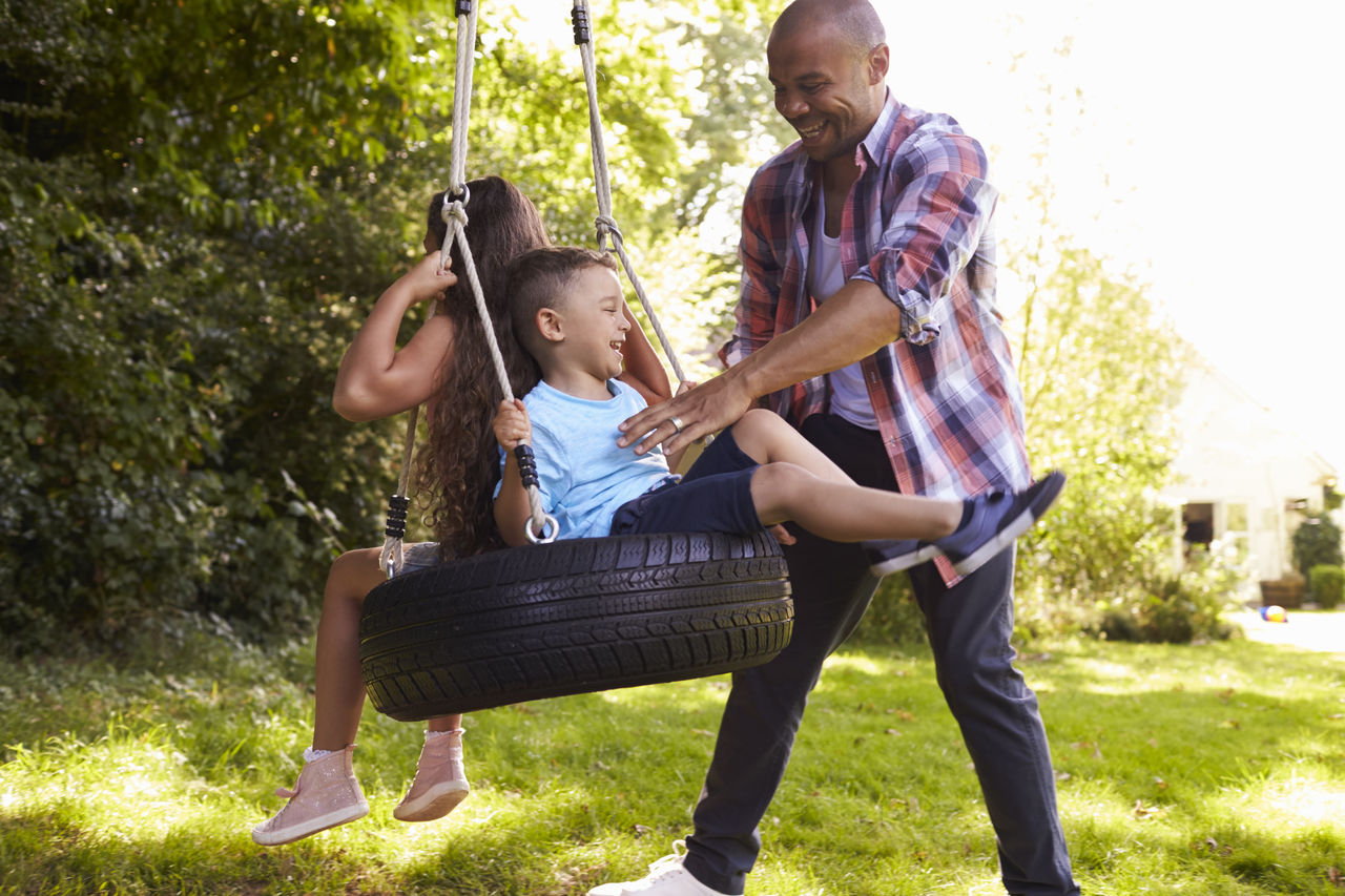 Father Pushing Children On Tire Swing In Garden; Shutterstock ID 496639498