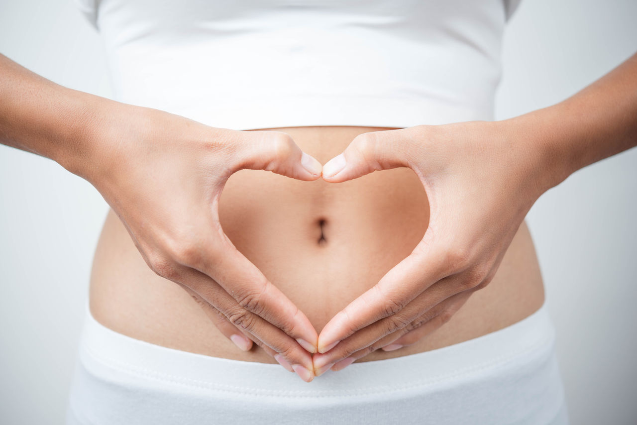 Close up of woman's hands made heart on belly isolated on white background.health care concept.; Shutterstock ID 583399804