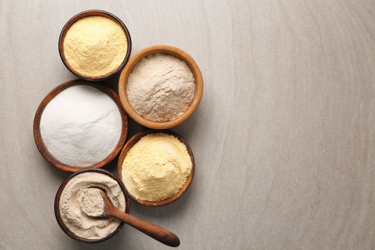 Wooden bowls with different types of flour on table; Shutterstock ID 669566476; purchase_order: COG Omyafood 120; job: ; client: ; other: 
