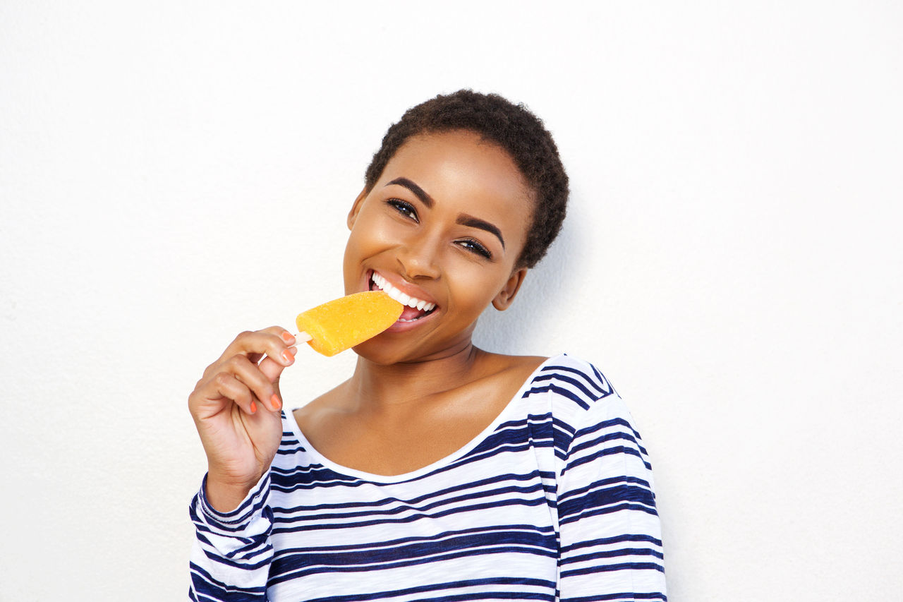 Portrait of young woman eating ice cream; Shutterstock ID 576995239