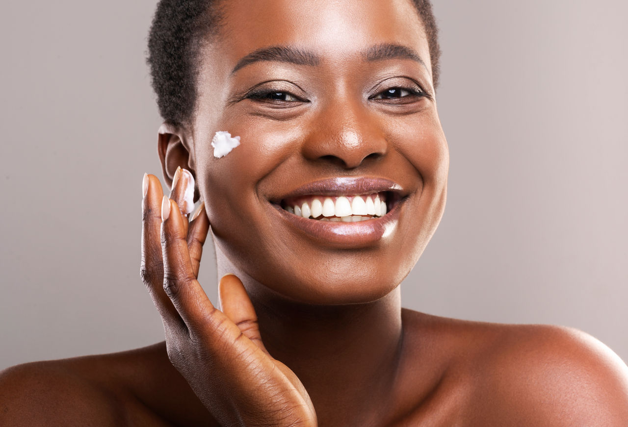 Woman applying cream on her face